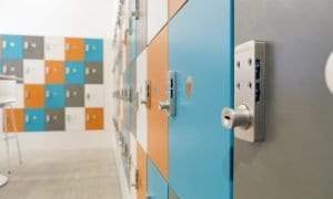 Workspace featuring laminate lockers alternating the following door colors: blue, grey, orange and white.