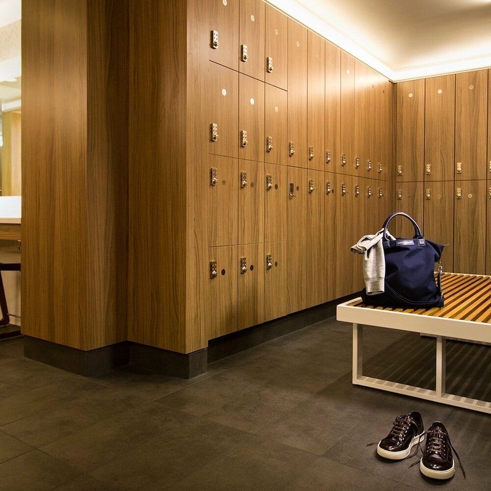 Long grooming station with individual stools and laminate lockers next to it at Equinox Metro Theater.